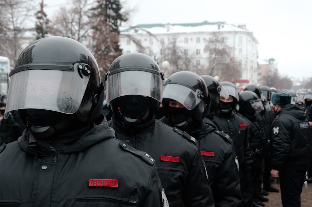 gruppo di uomini che indossano casco nero e giacca nera
