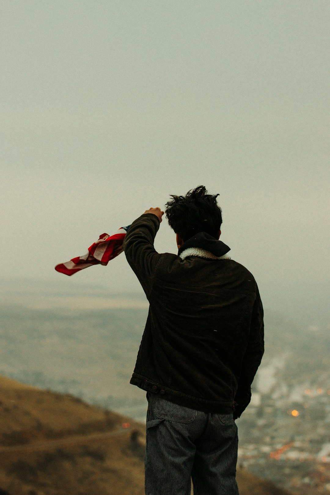 person in black jacket holding red and white plastic cup