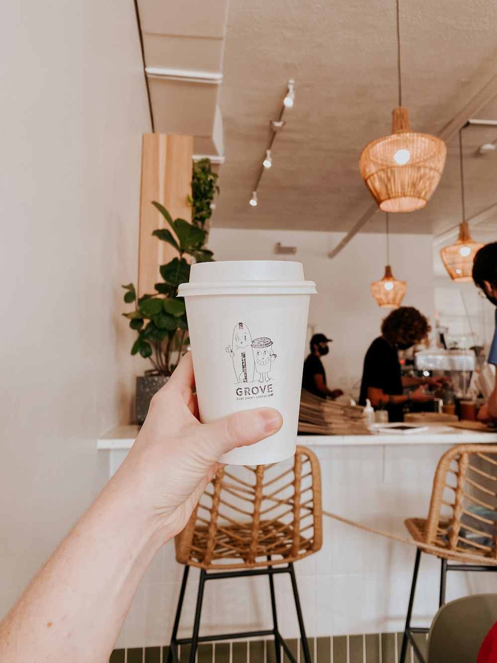 person holding white disposable cup