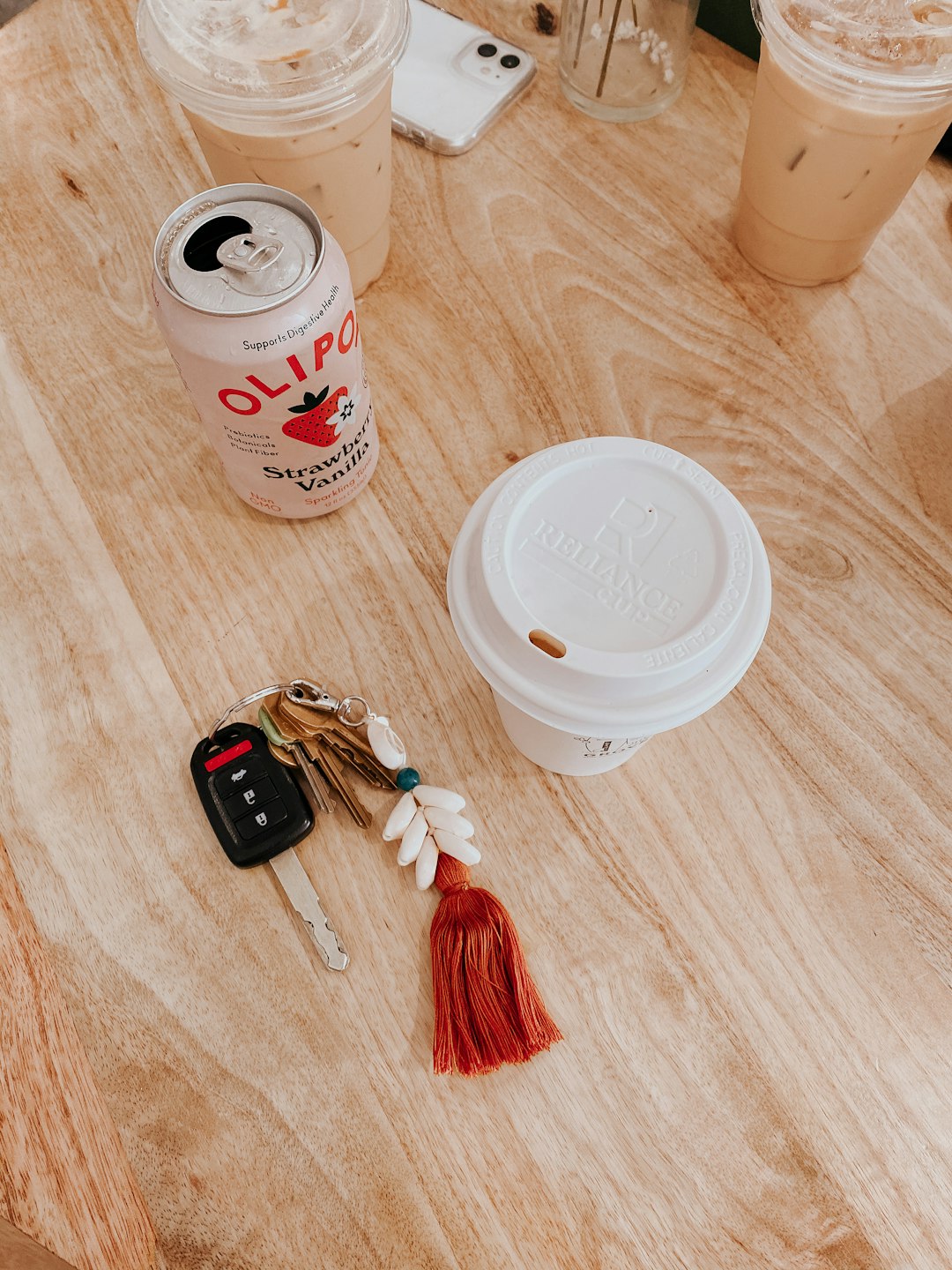 black and red car key beside white disposable cup