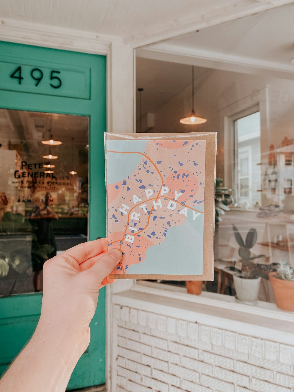 person holding white and blue paper with heart drawing