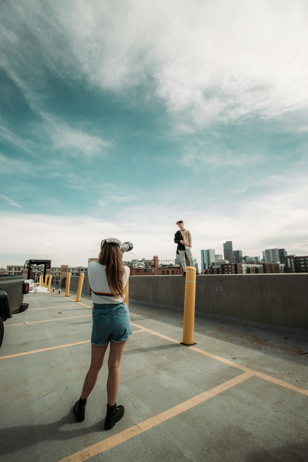 woman in blue denim shorts standing on gray concrete floor during daytime