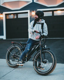 man in white jacket riding on black bicycle