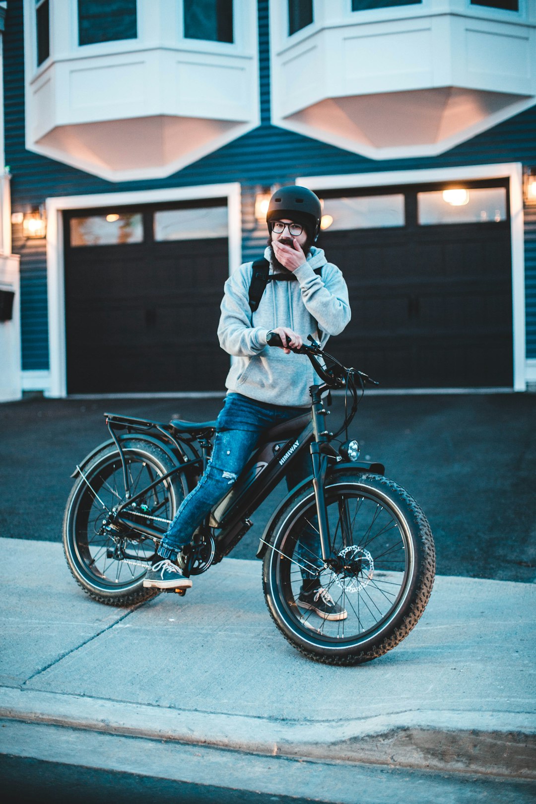 woman in white jacket riding on blue bicycle