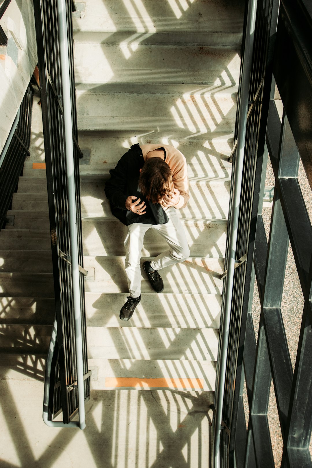 woman in white long sleeve shirt and black pants sitting on stairs