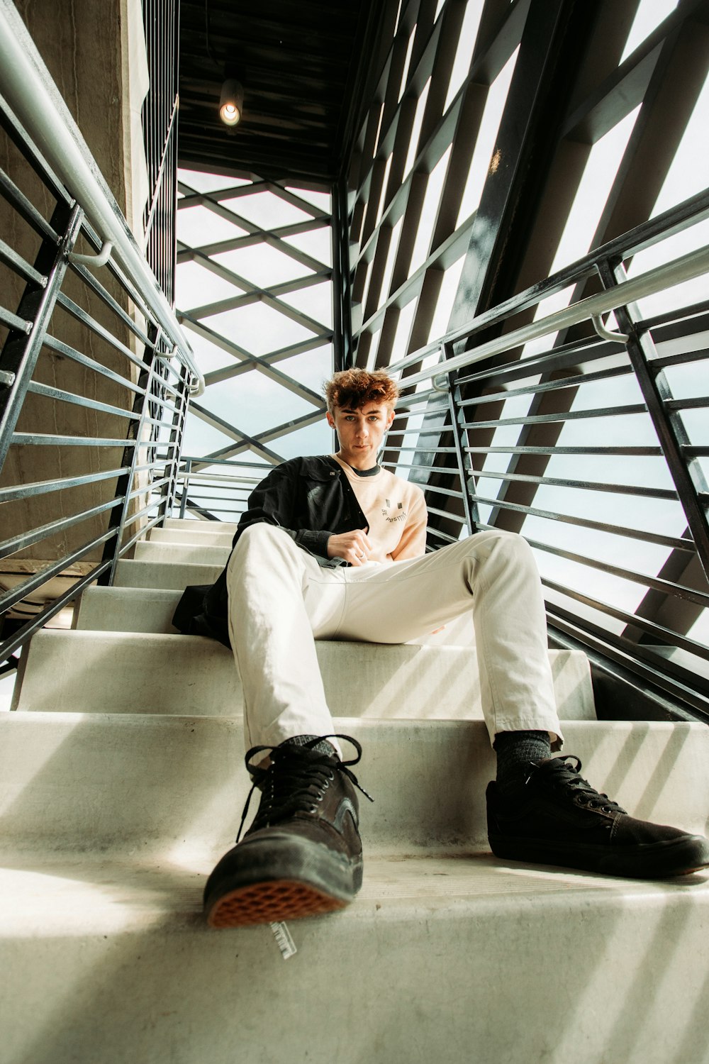 man in black blazer sitting on stairs