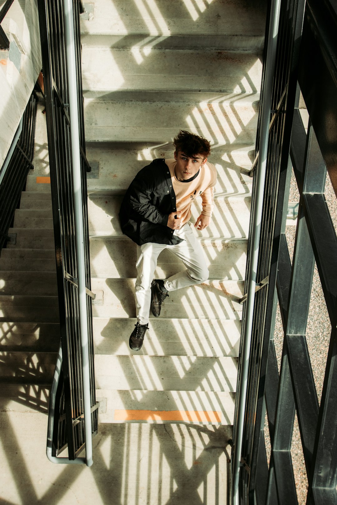 man in black jacket sitting on the stairs