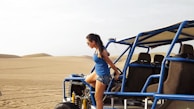woman in blue tank top and blue denim shorts sitting on blue car during daytime