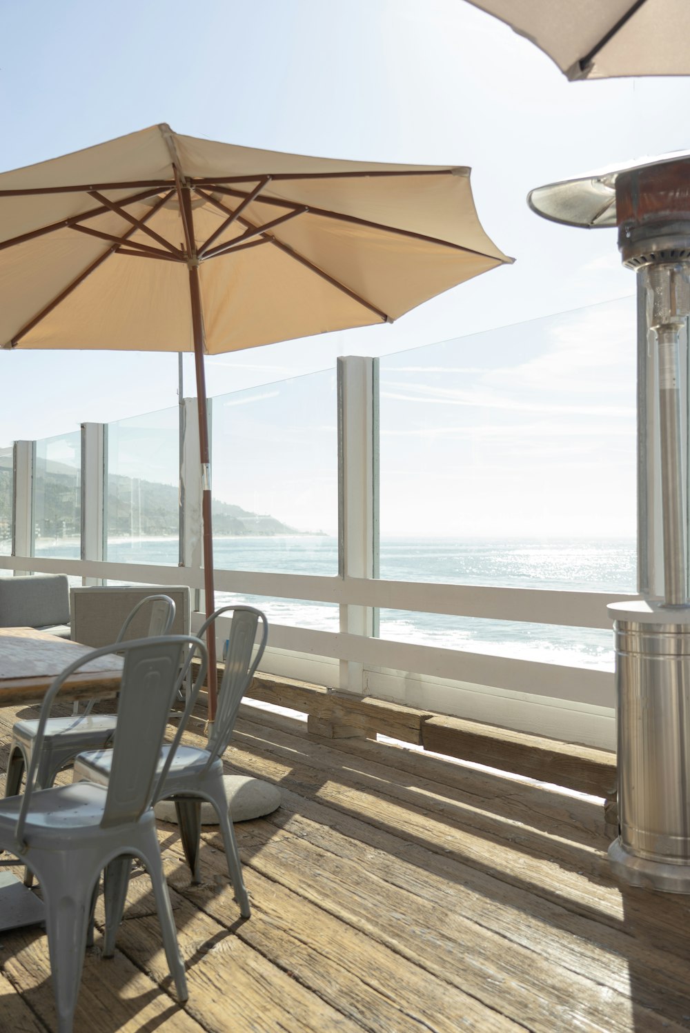 brown patio umbrella near black wooden armchair