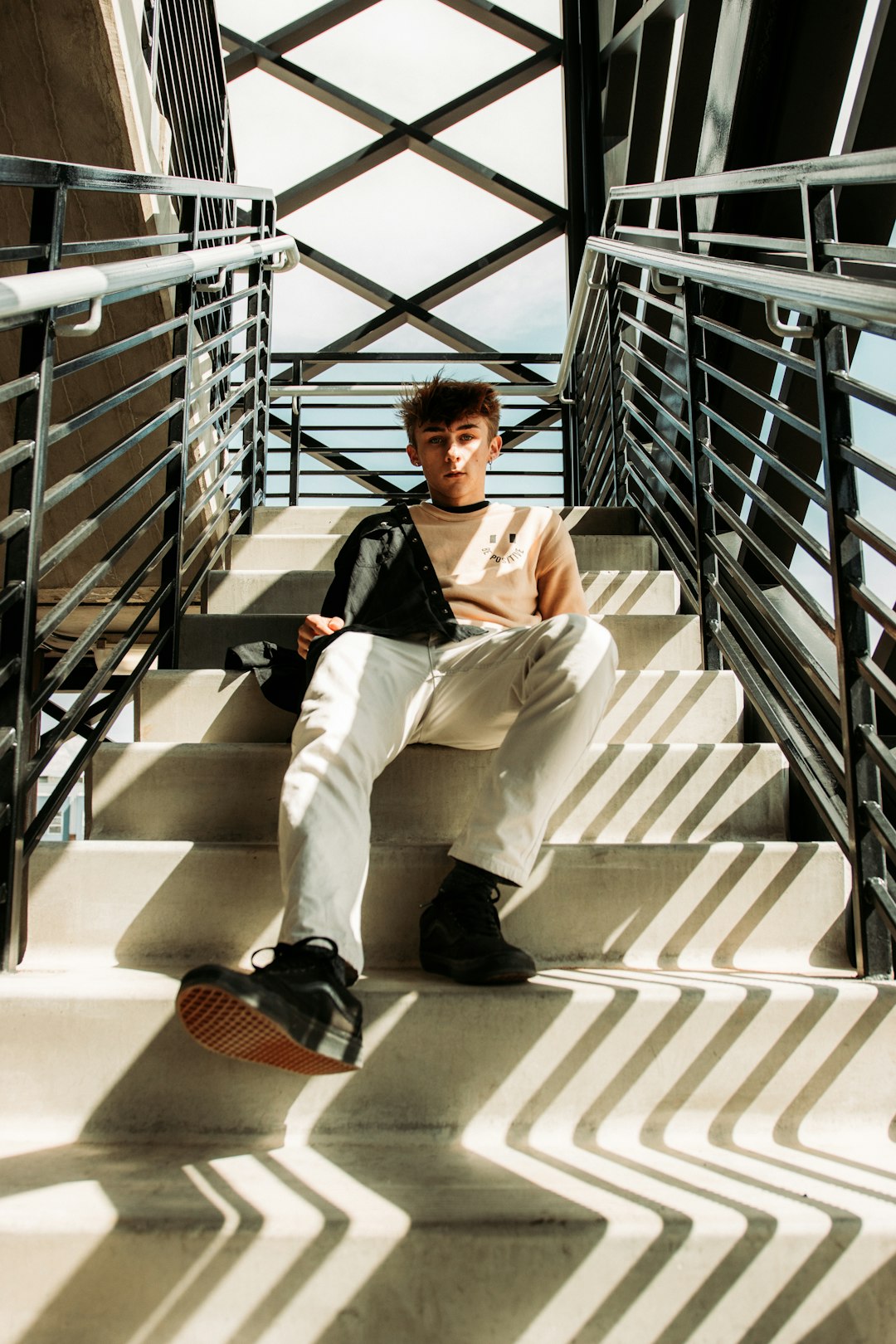 woman in white pants sitting on white staircase