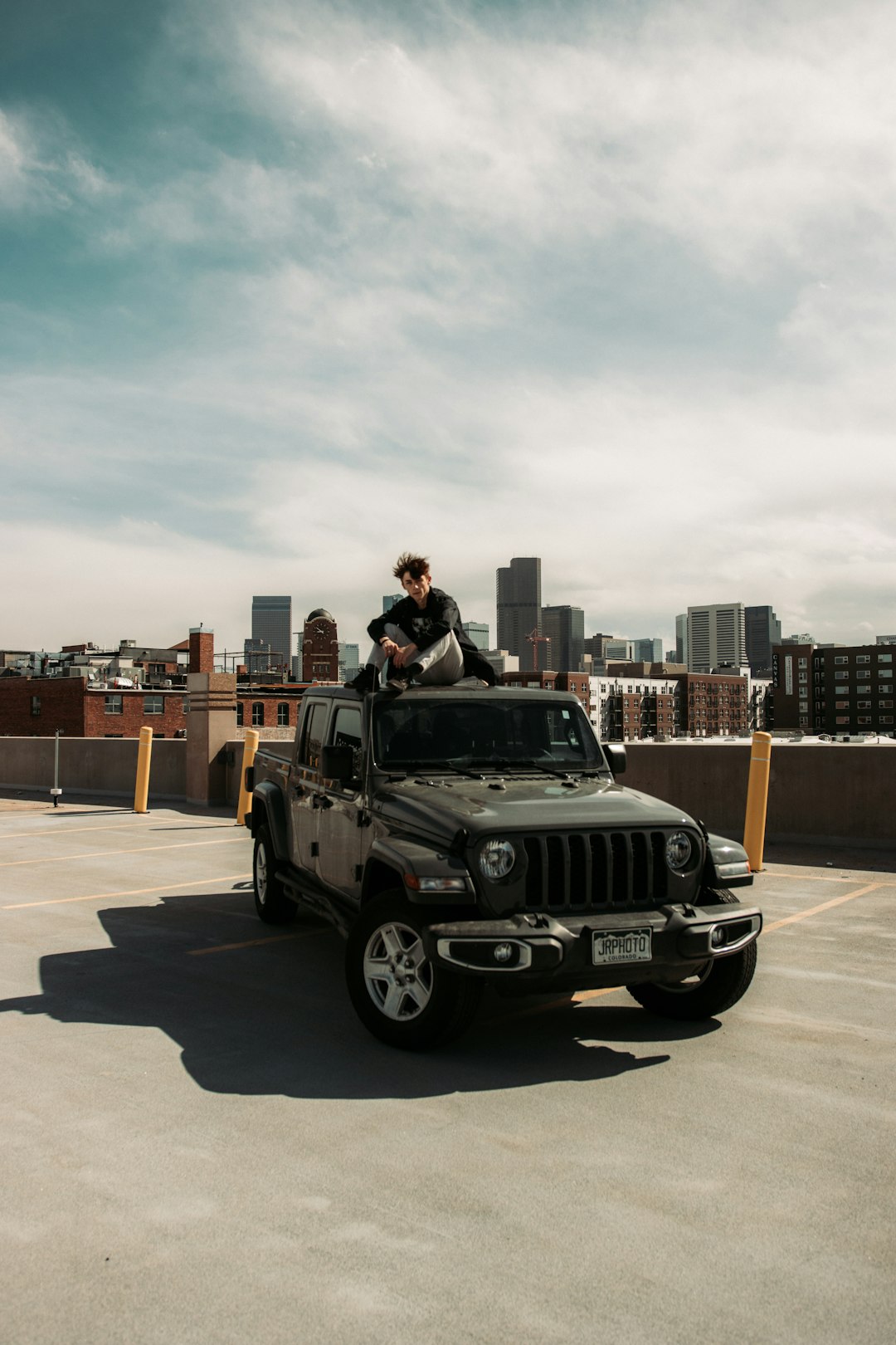 man in black jacket standing beside black jeep wrangler