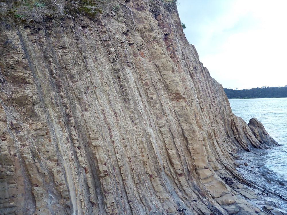 brown rock formation near body of water during daytime