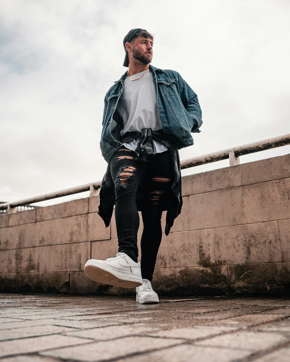 man in gray jacket and black pants standing on concrete stairs