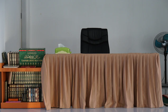 A warm, elegant office space with shelves filled with academic and Islamic books, reflecting a scholarly atmosphere.