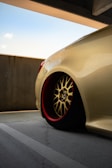 Elegant shot of a car wheel with a matte gold finish against a clean, light gray backdrop.
