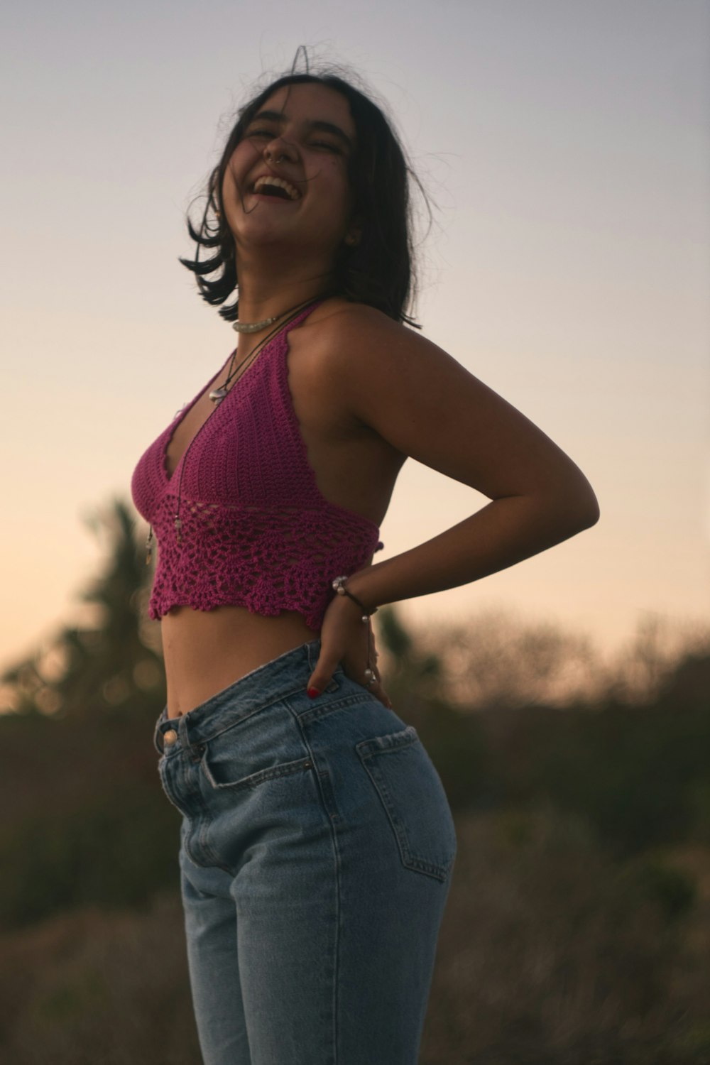 woman in purple sports bra and blue denim jeans