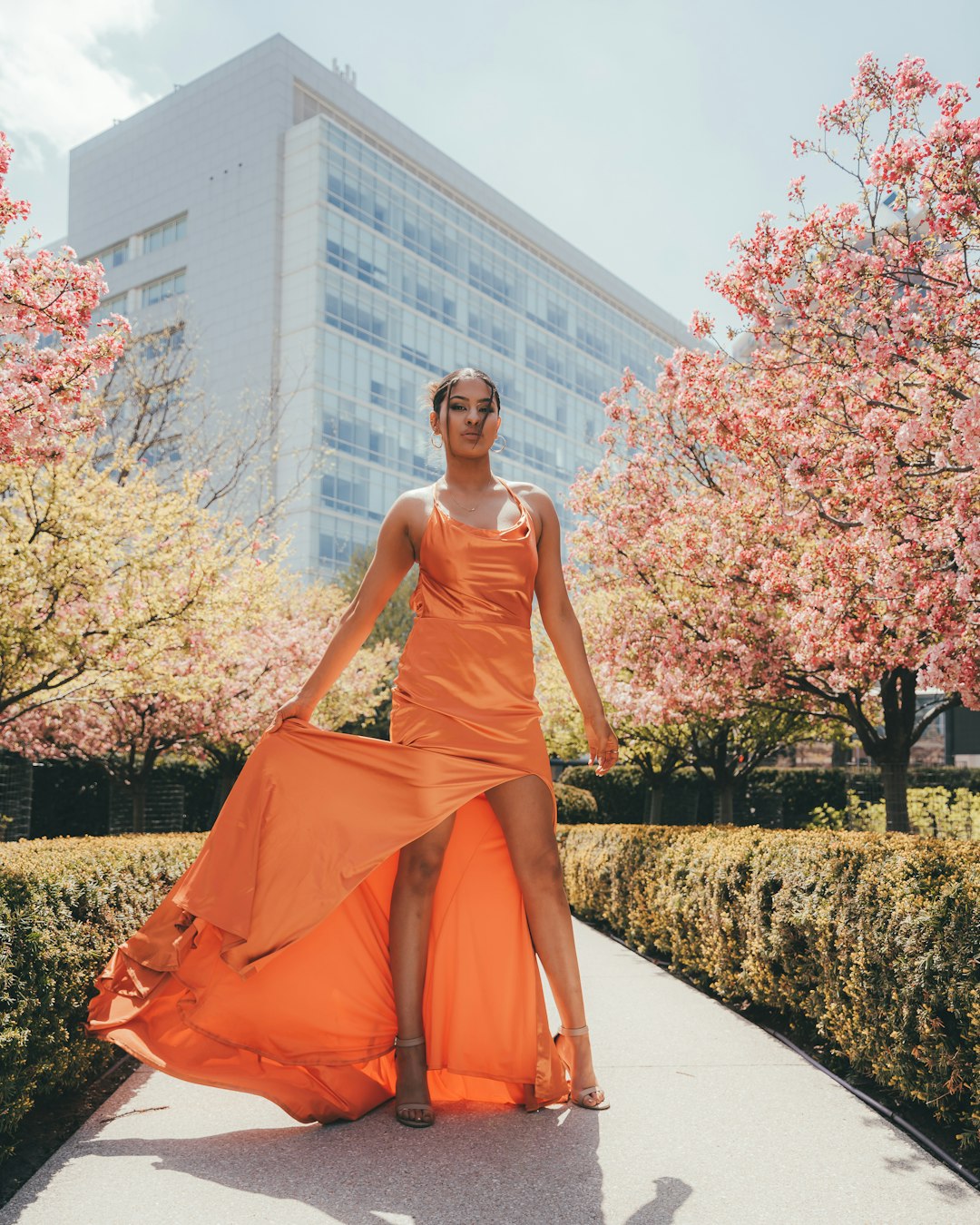 woman in orange sleeveless dress standing on pathway