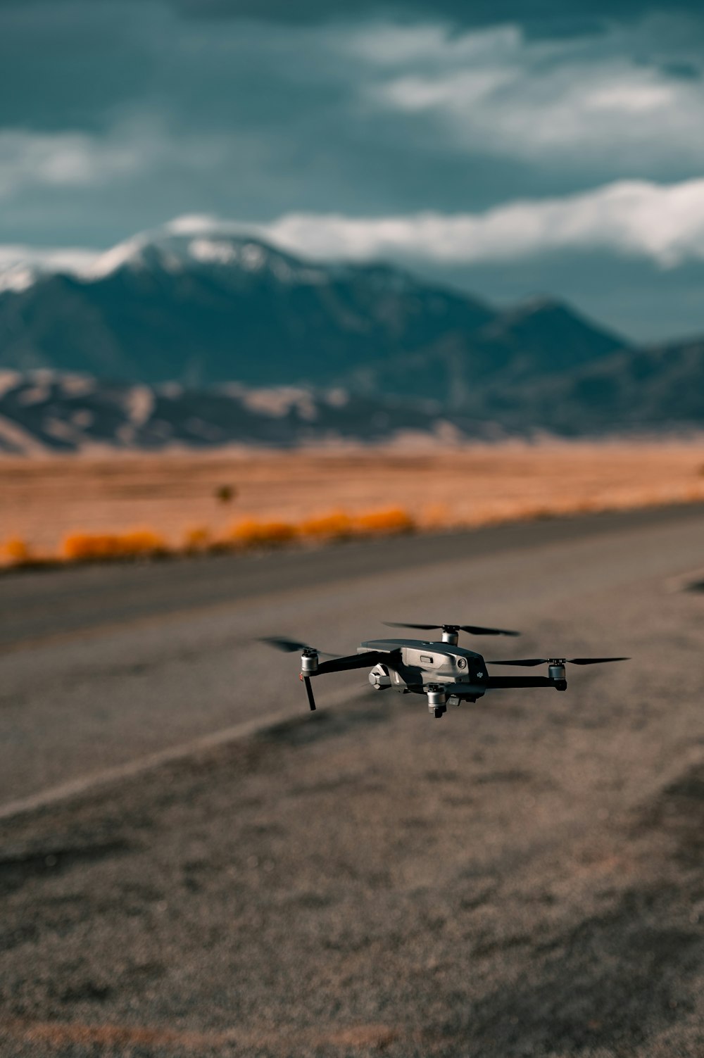 Drone in bianco e nero che vola sopra il campo marrone durante il giorno