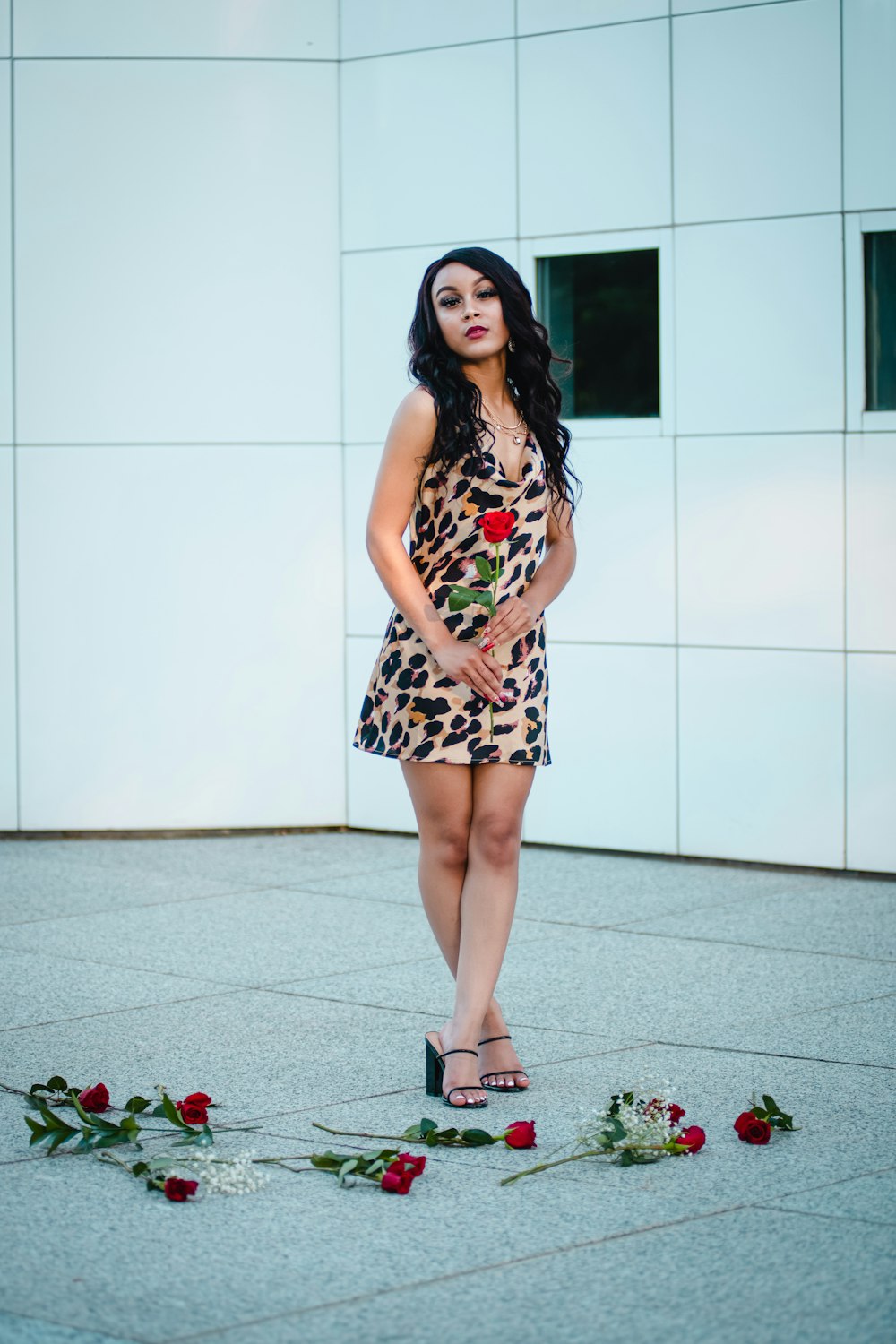 woman in black and white floral dress standing on gray floor