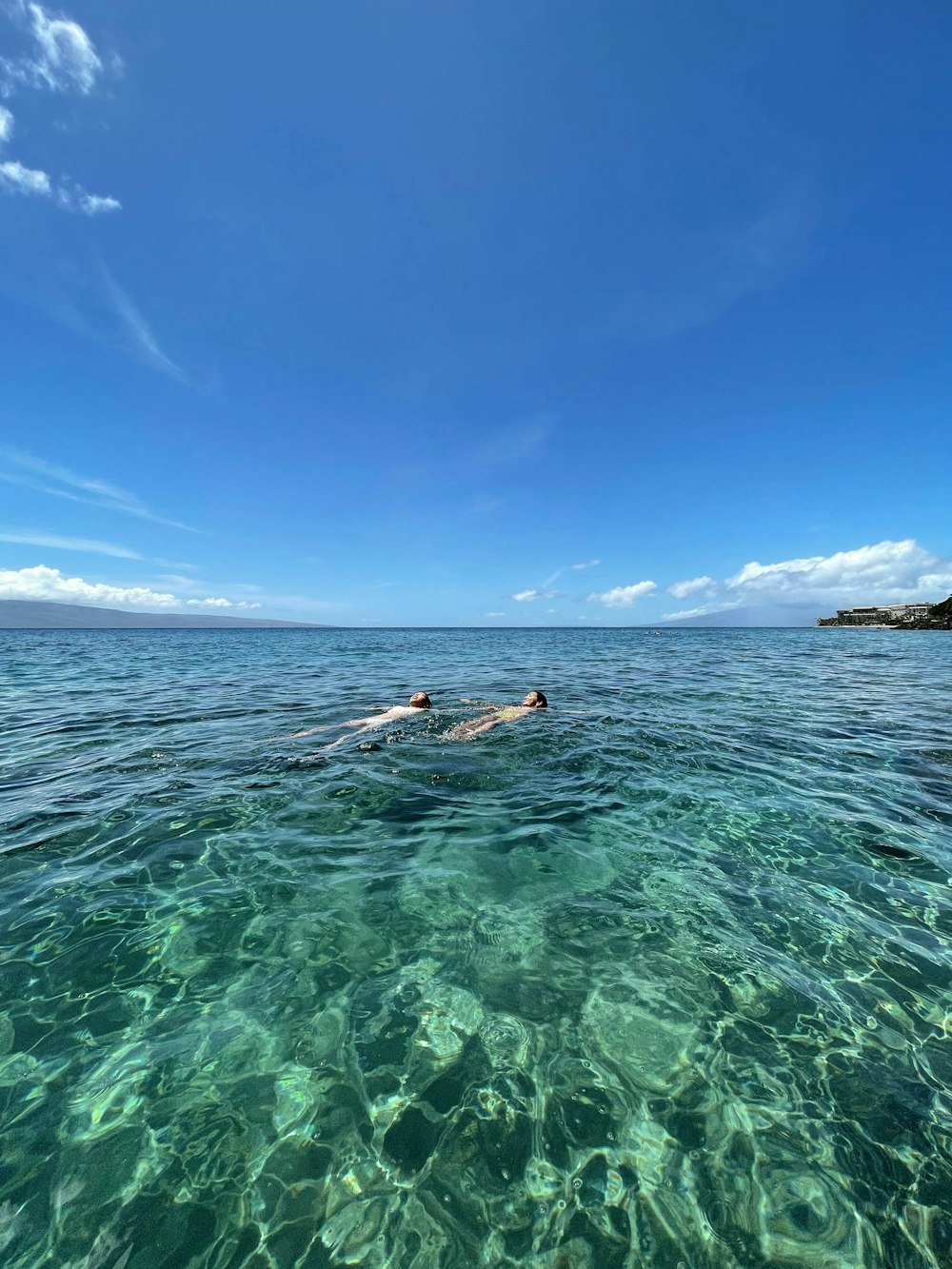 woman in blue bikini swimming on sea during daytime