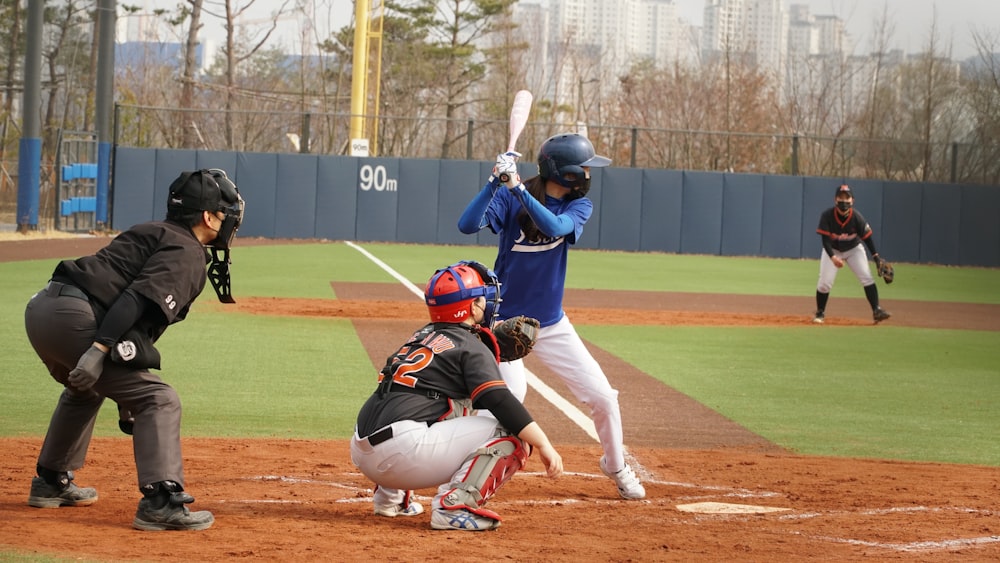 man in blue helmet and white pants playing baseball during daytime