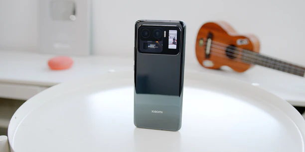 Close-up of a sleek mobile phone resting on a wooden table with uk mobile shop branding.
