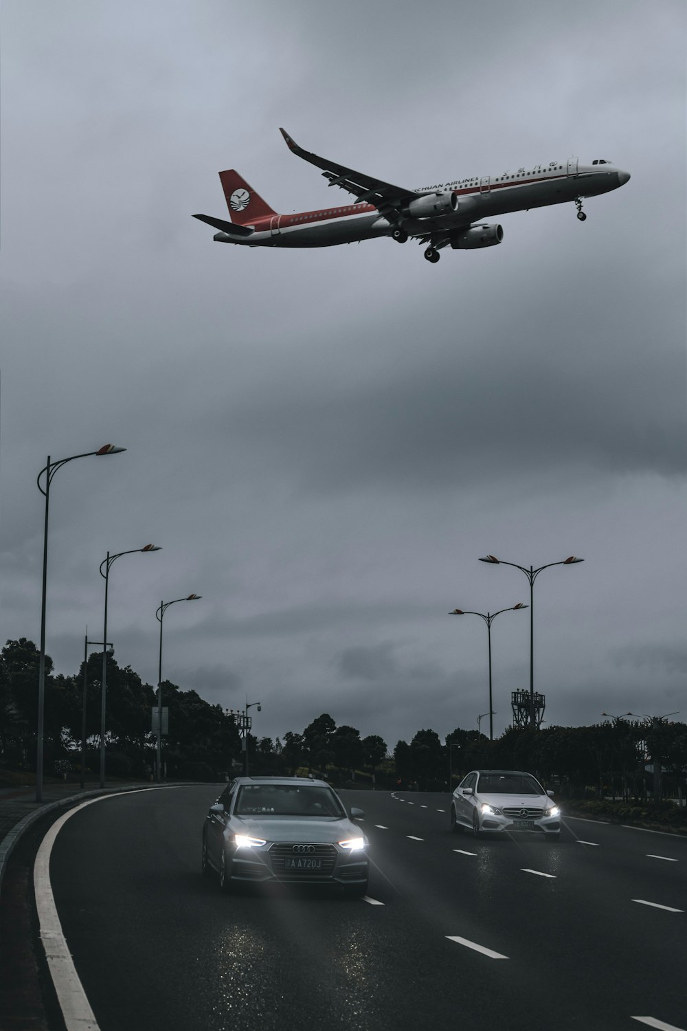 昼間の道路を走る白と赤の飛行機