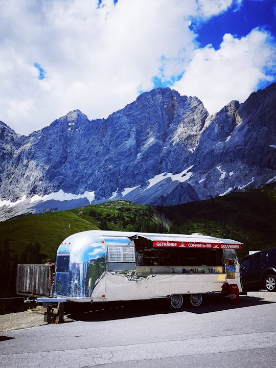red and white bus near mountain during daytime in Dachstein Austria