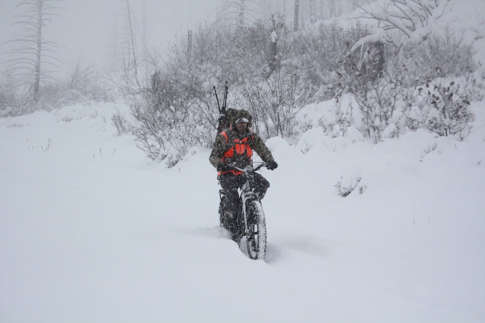 man in black jacket riding on black motorcycle on snow covered ground during daytime