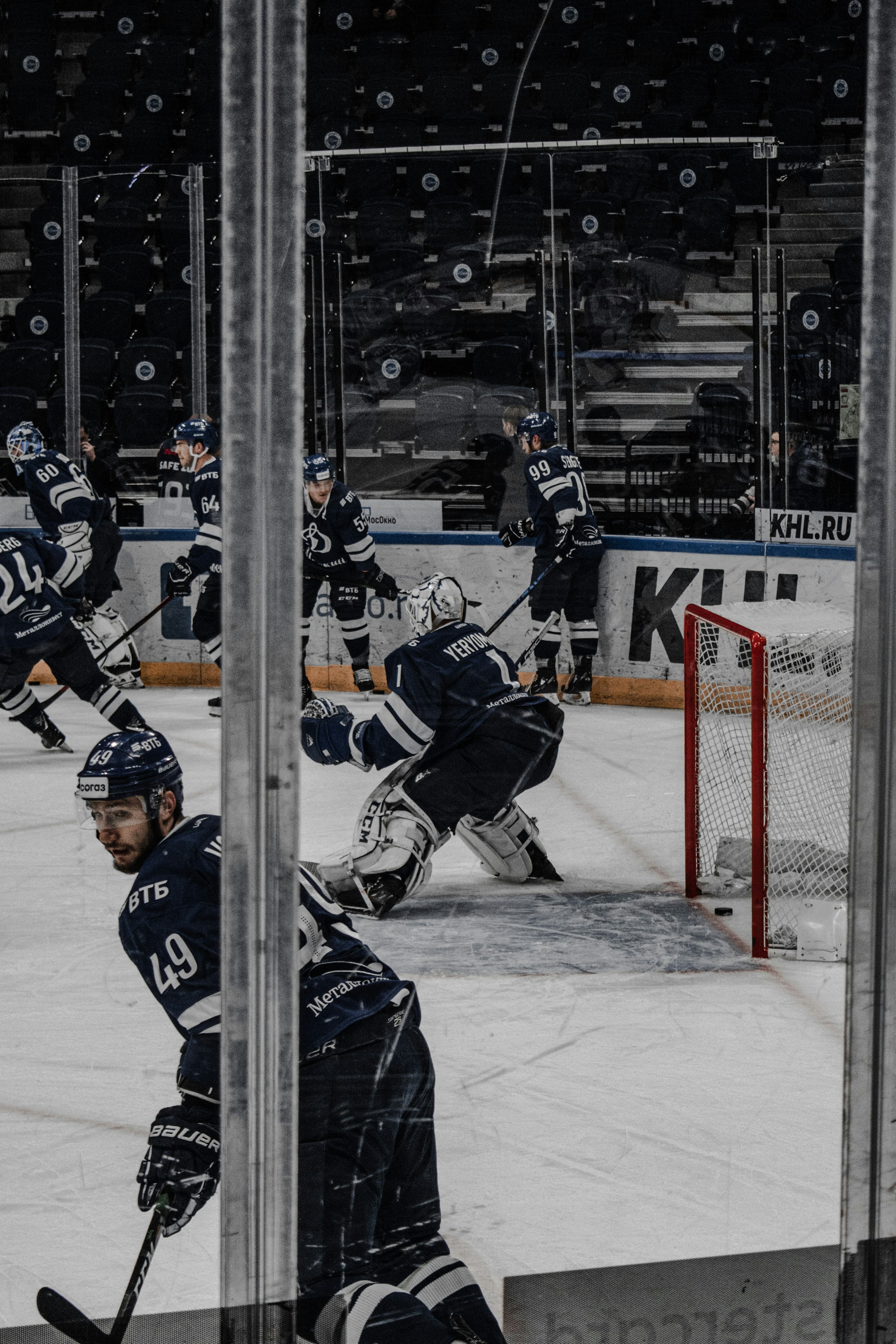 man in black ice hockey jersey riding on ice hockey stick