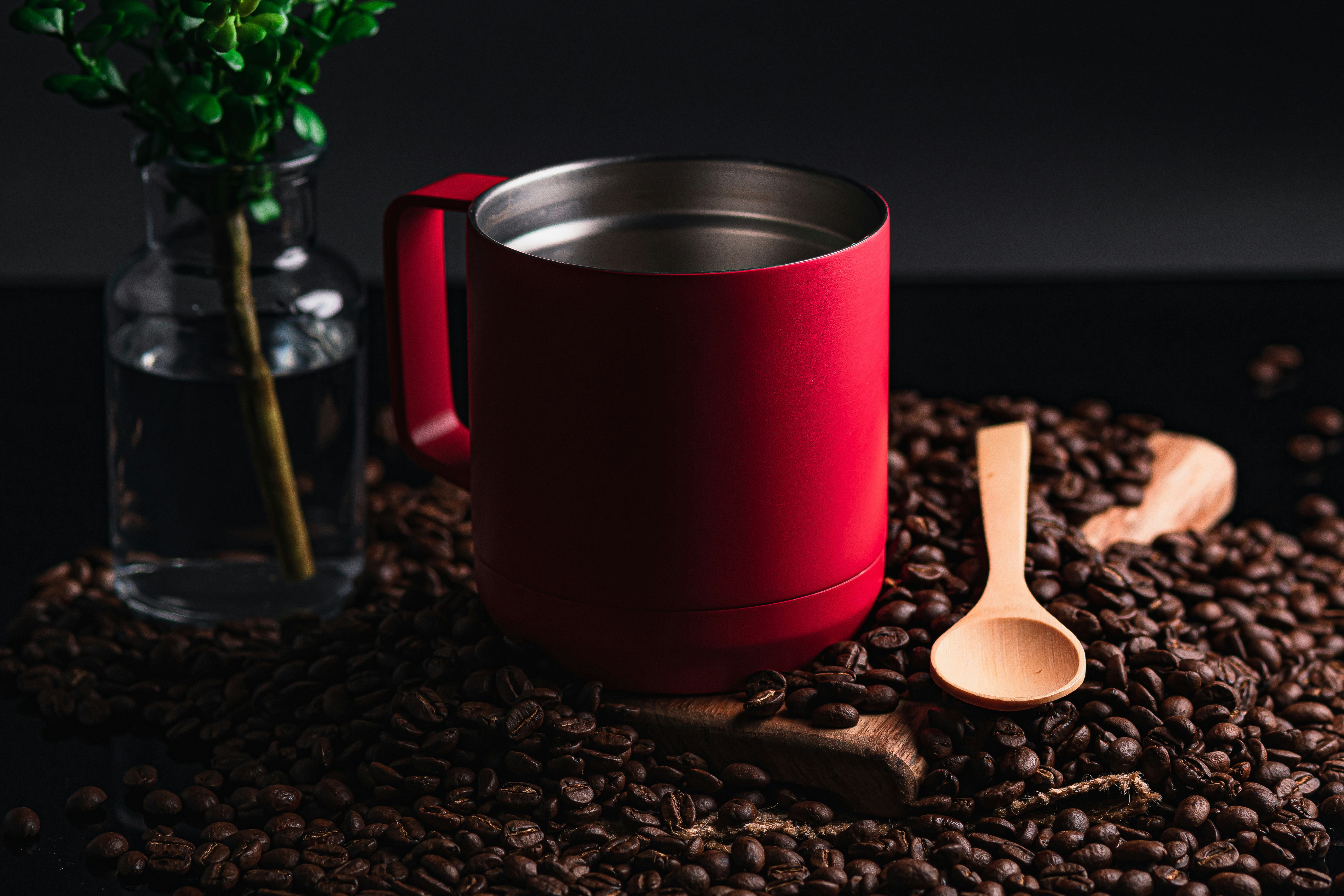 Taza roja y plateada en cuchara de madera marrón