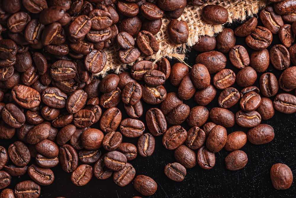 brown coffee beans on black surface