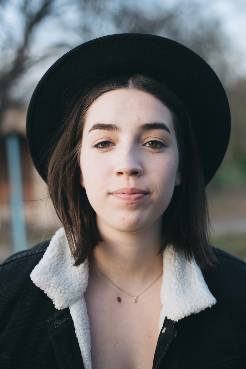 woman in black and white coat wearing black hat