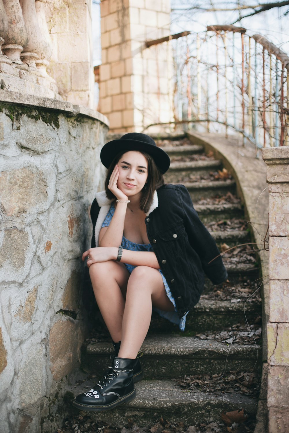 woman in black coat sitting on concrete stairs