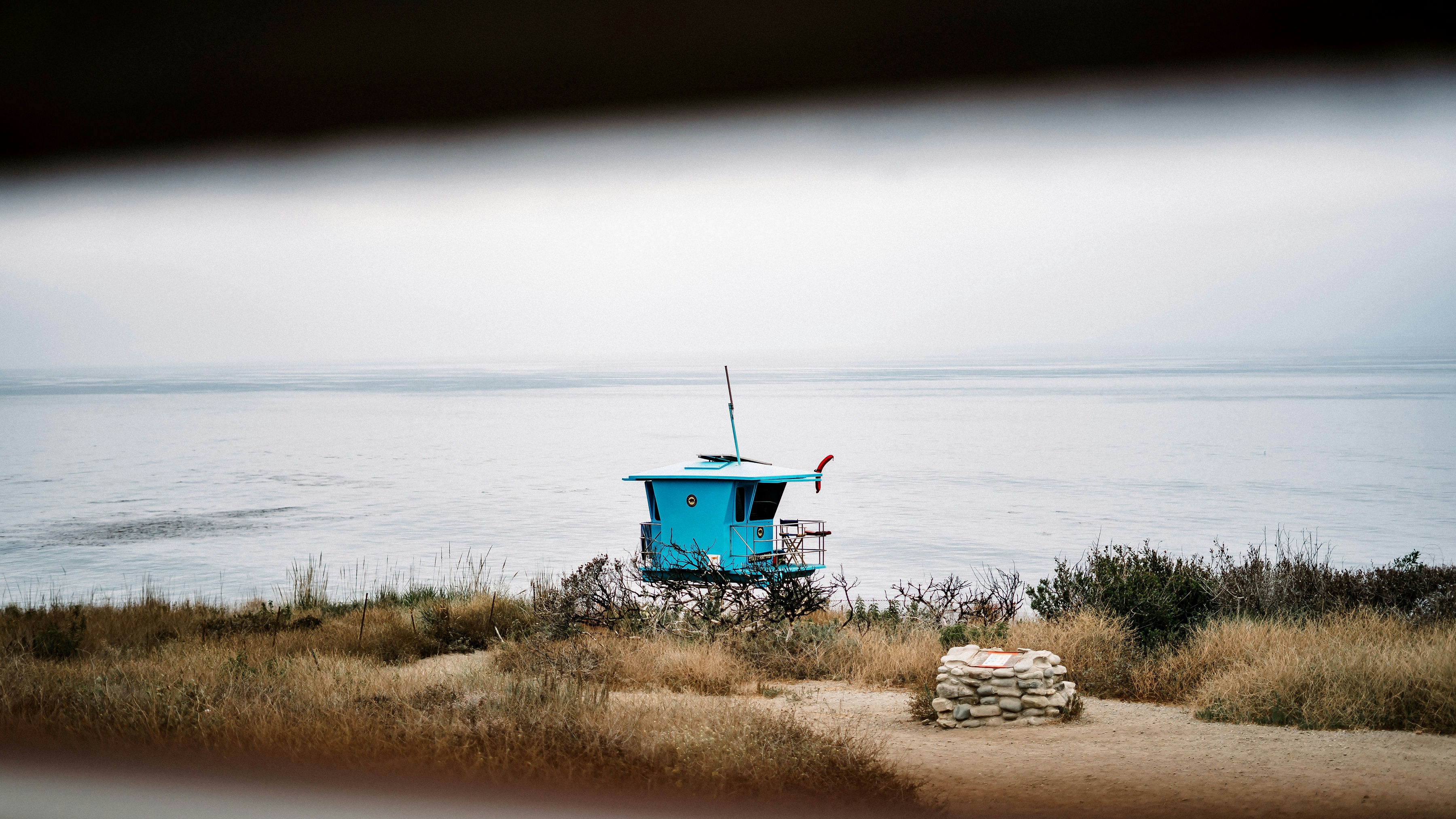 blue and green wooden house near body of water during daytime