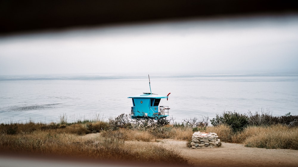 blue and green wooden house near body of water during daytime