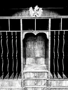 A compact pooja mandir with built-in storage drawers, crafted from rich wood and adorned with delicate carvings.