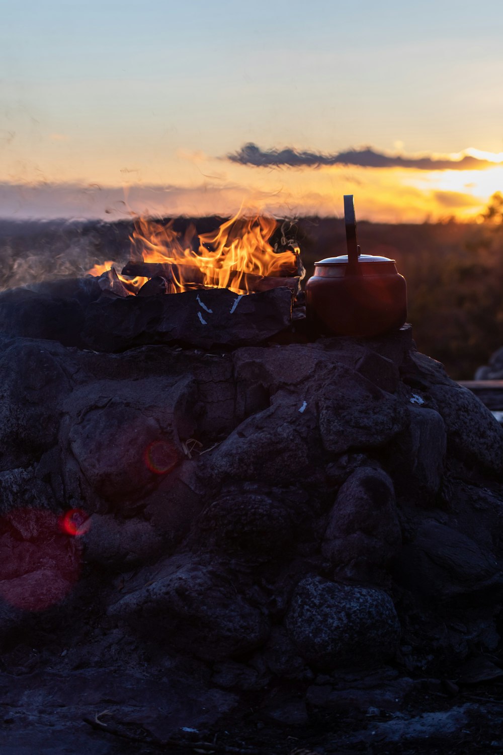 Fuego en fogata negra durante la puesta del sol