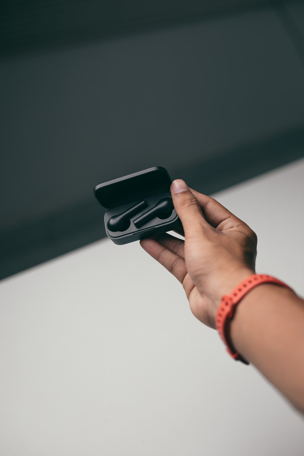 person holding black smartphone with brown leather strap