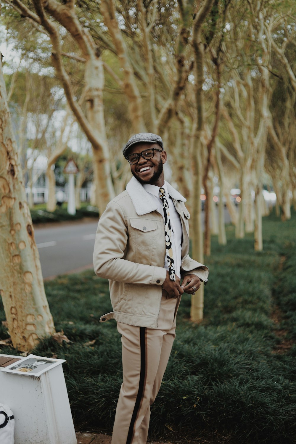 man in gray coat standing on green grass field during daytime