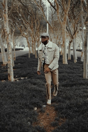 A spring ensemble showing a man in a light jacket and chinos, walking through a blooming garden.