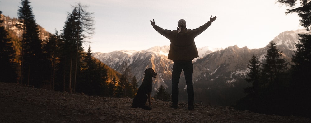 silhouette of man standing on mountain during daytime