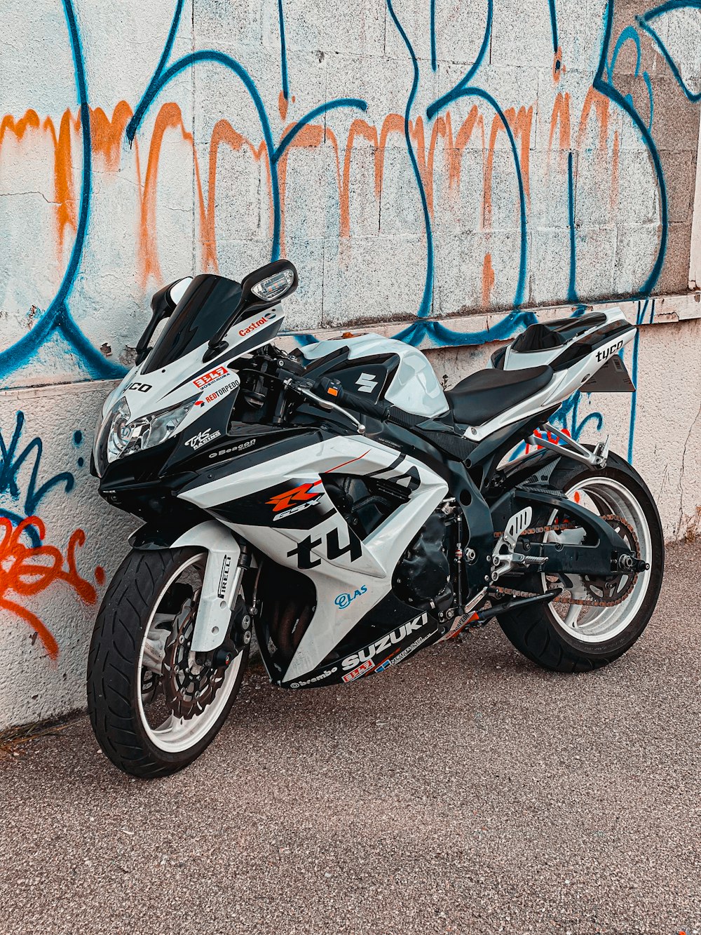 black and white sports bike parked beside blue and white wall