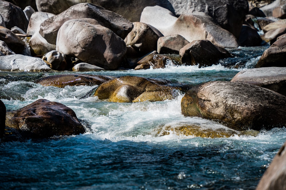 gray rocks on body of water during daytime