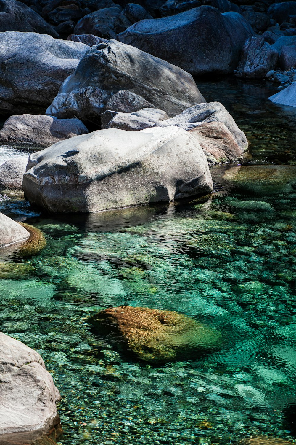 rochas cinzentas no corpo de água durante o dia