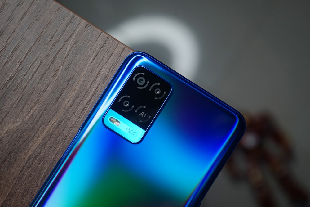 smartphone azul e preto na mesa de madeira marrom