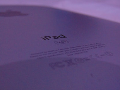 The close-up image focuses on the back of an iPad with the storage capacity clearly marked as 16GB. The branding and regulatory information are visible, set against a backdrop of subtle lighting, giving a muted purple hue.