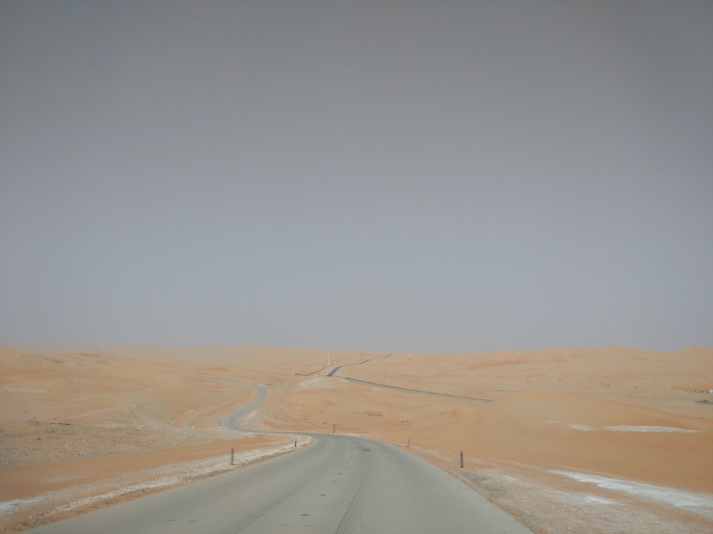 brown sand field under blue sky during daytime