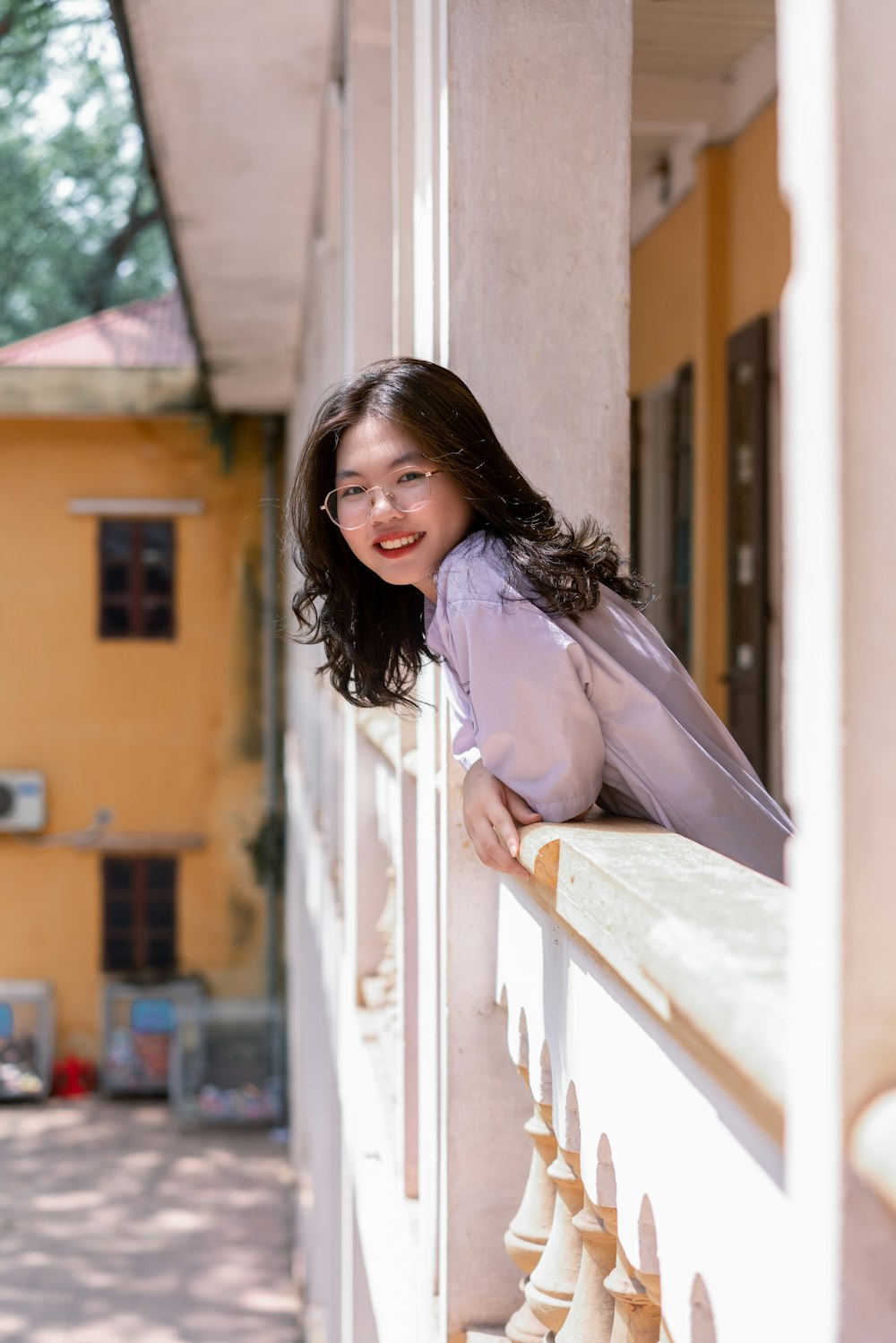 woman in white long sleeve shirt leaning on white wooden window