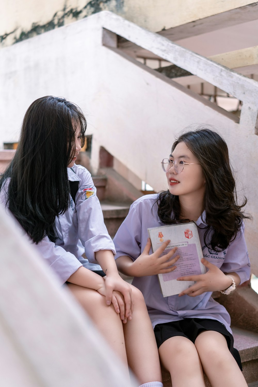 woman in white button up shirt holding white book